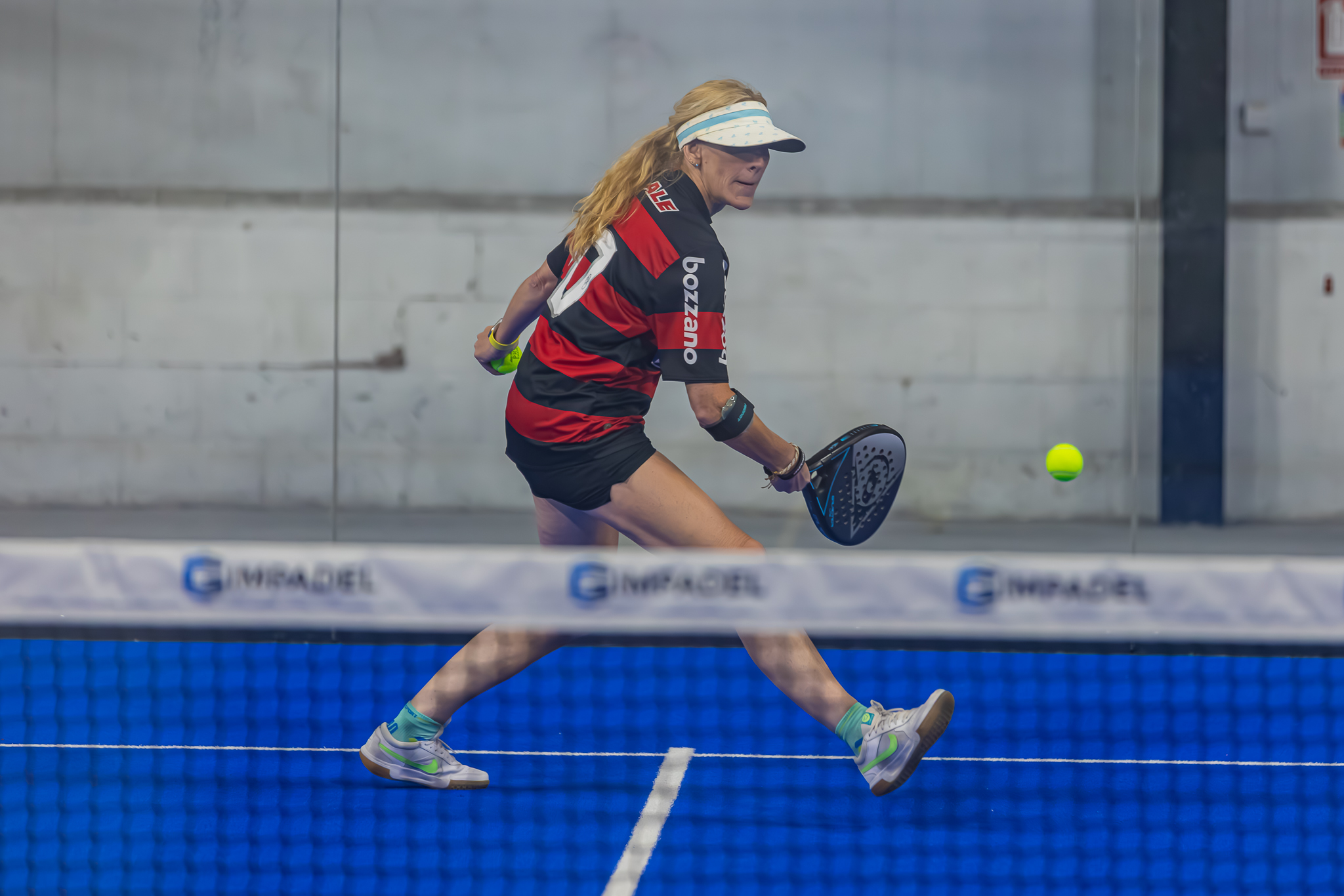 A player returning a ball on an indoor court at RC24