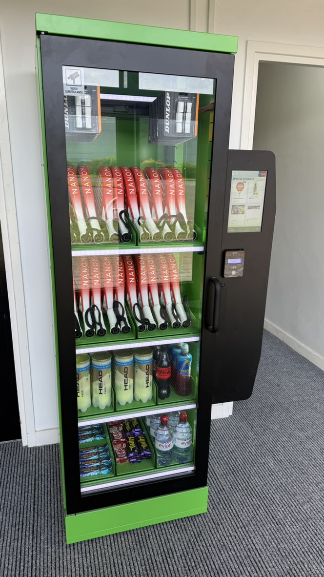 The green racket rental and ball vending machine at Racquet Club 24